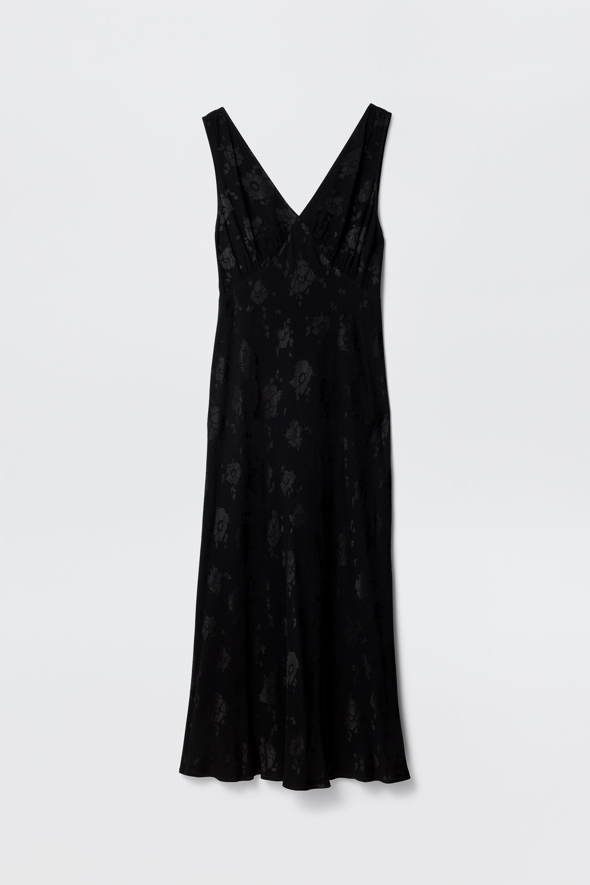 The Sandrine - Black Poppy Jacquard is a sleeveless midi dress with a subtle poppy floral jacquard pattern, deep V-neckline, and slightly flared hem, shown against a plain white background.
