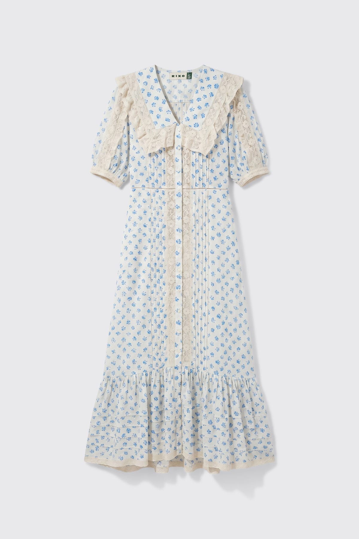 Edina - Seville Floral Cream dress featuring light blue floral patterns, short sleeves, lace trim, a large lace collar, front buttons, and a ruffled hem, displayed on a white background.