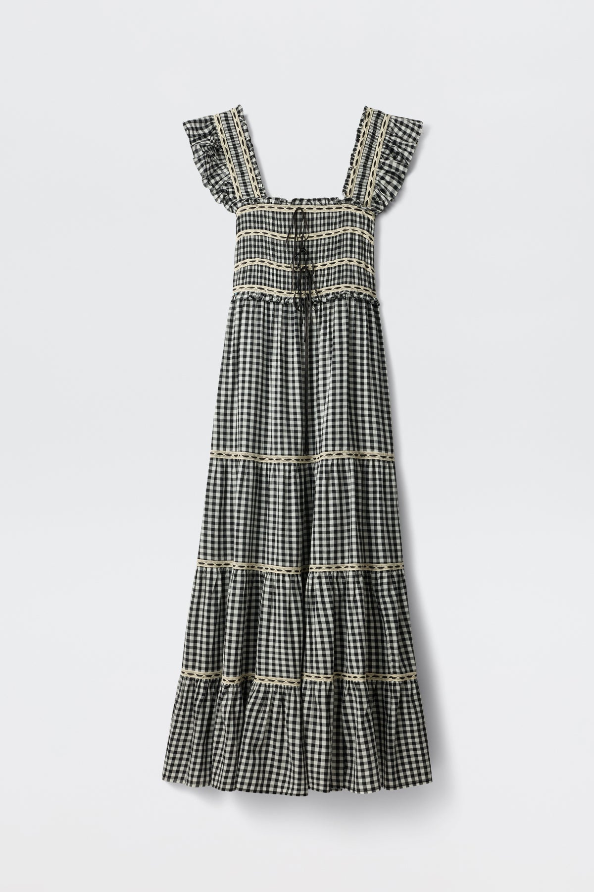 The Chandra - Beth Check Black is a sleeveless, ankle-length dress featuring a black and white gingham pattern, square neckline, ruffled straps, tiered skirt with lace trim on each tier, and vintage cottagecore style.