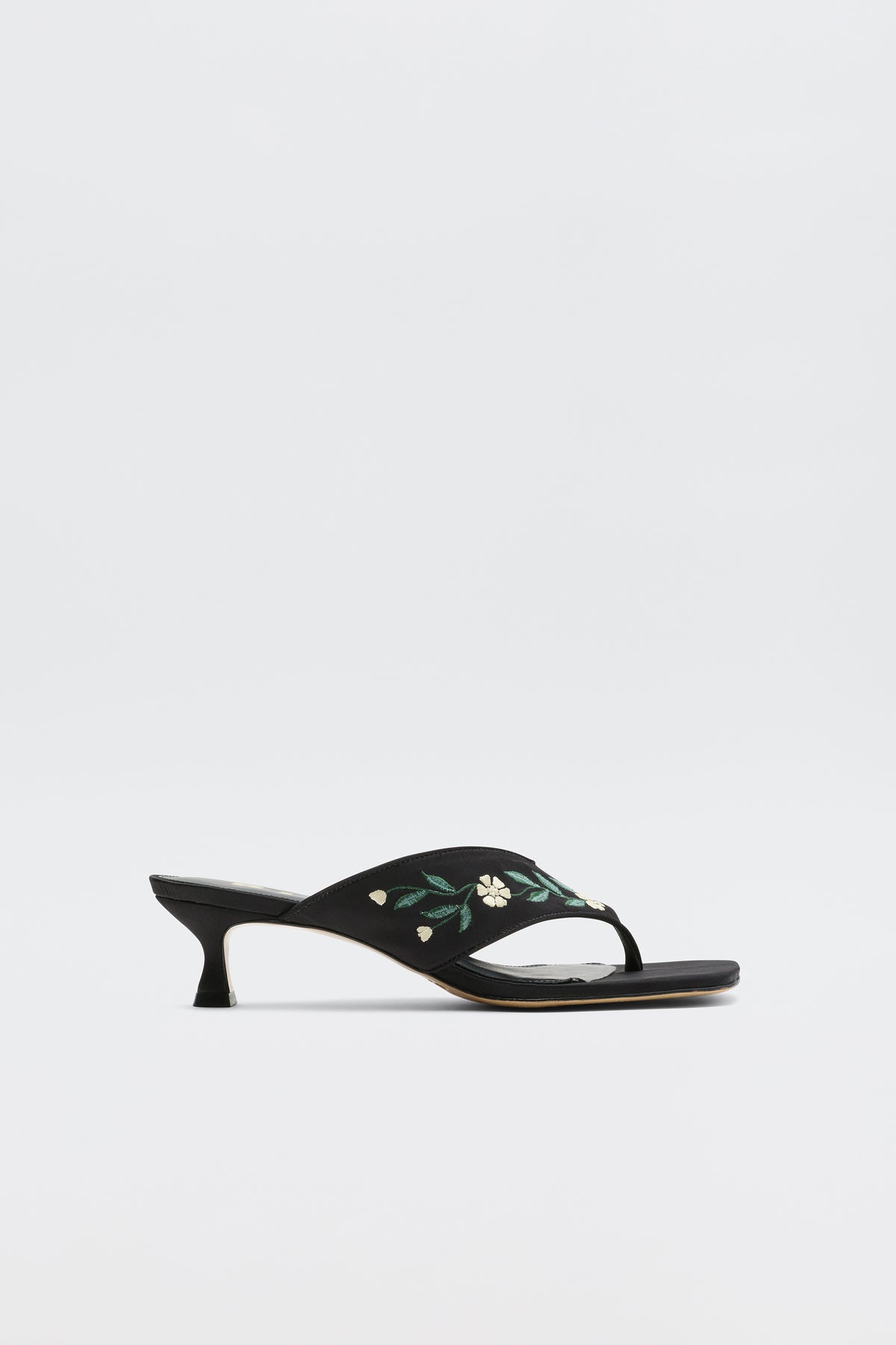 The Zoya - Blossom Embroidery Black sandals are black open-toe satin heels with a low kitten heel and yellow-green floral embroidery on the strap, shown against a plain white background.