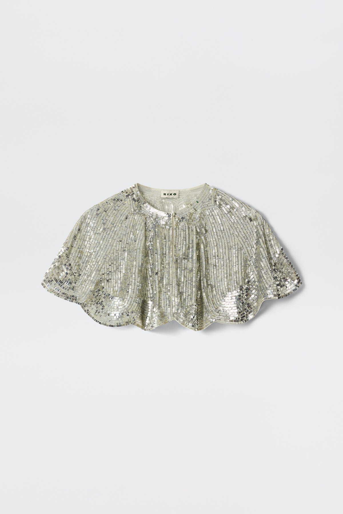 The Evienne - Art Deco Embellishment Pearl is a silver sequin capelet featuring a short, scalloped hem and gathered details, inspired by Art Deco capes, shown against a plain light background.