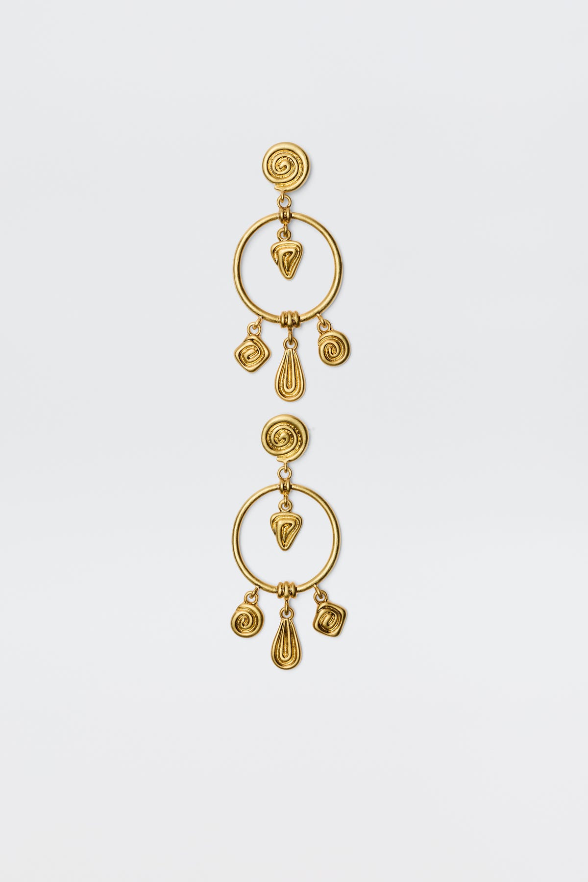 The Thome - Gold earrings feature circular posts, large open hoops, and dangling spiral and teardrop geometric charms for a bohemian look, shown against a plain white background.