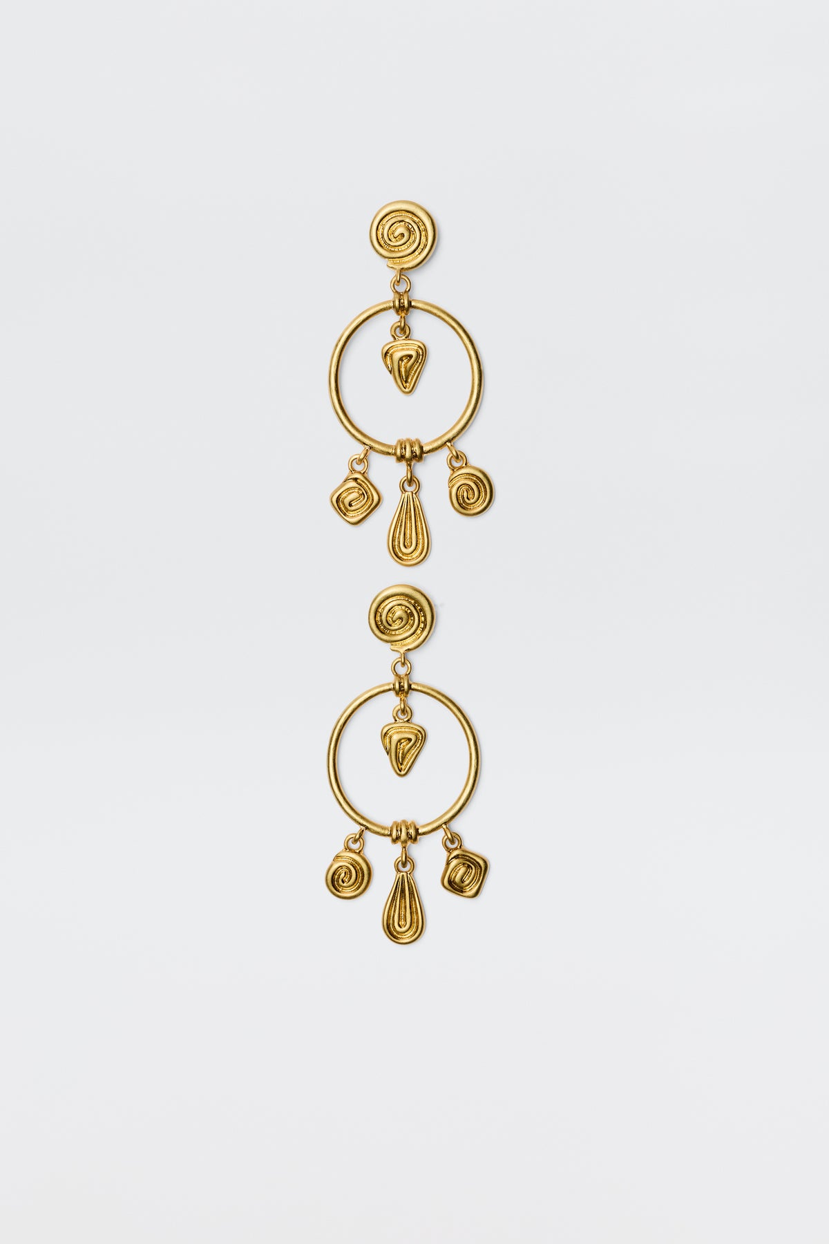 The Thome - Gold earrings feature circular posts, large open hoops, and dangling spiral and teardrop geometric charms for a bohemian look, shown against a plain white background.