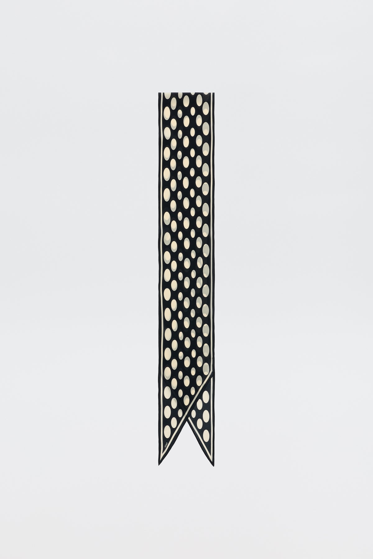 The Nara - Oval Spot Navy scarf is a chic pure silk piece with a navy ribbon, large white oval spots, a slim white border, and a split two-pointed end where one point slightly overlaps the other.