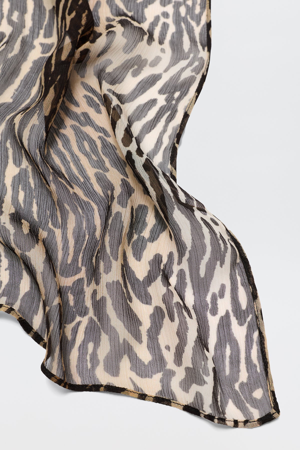 Julien - Bohemia Leopard is a sheer, lightweight fabric featuring a black, beige, and tan Bohemia Leopard print, elegantly draped—ideal for creating stylish printed dresses.