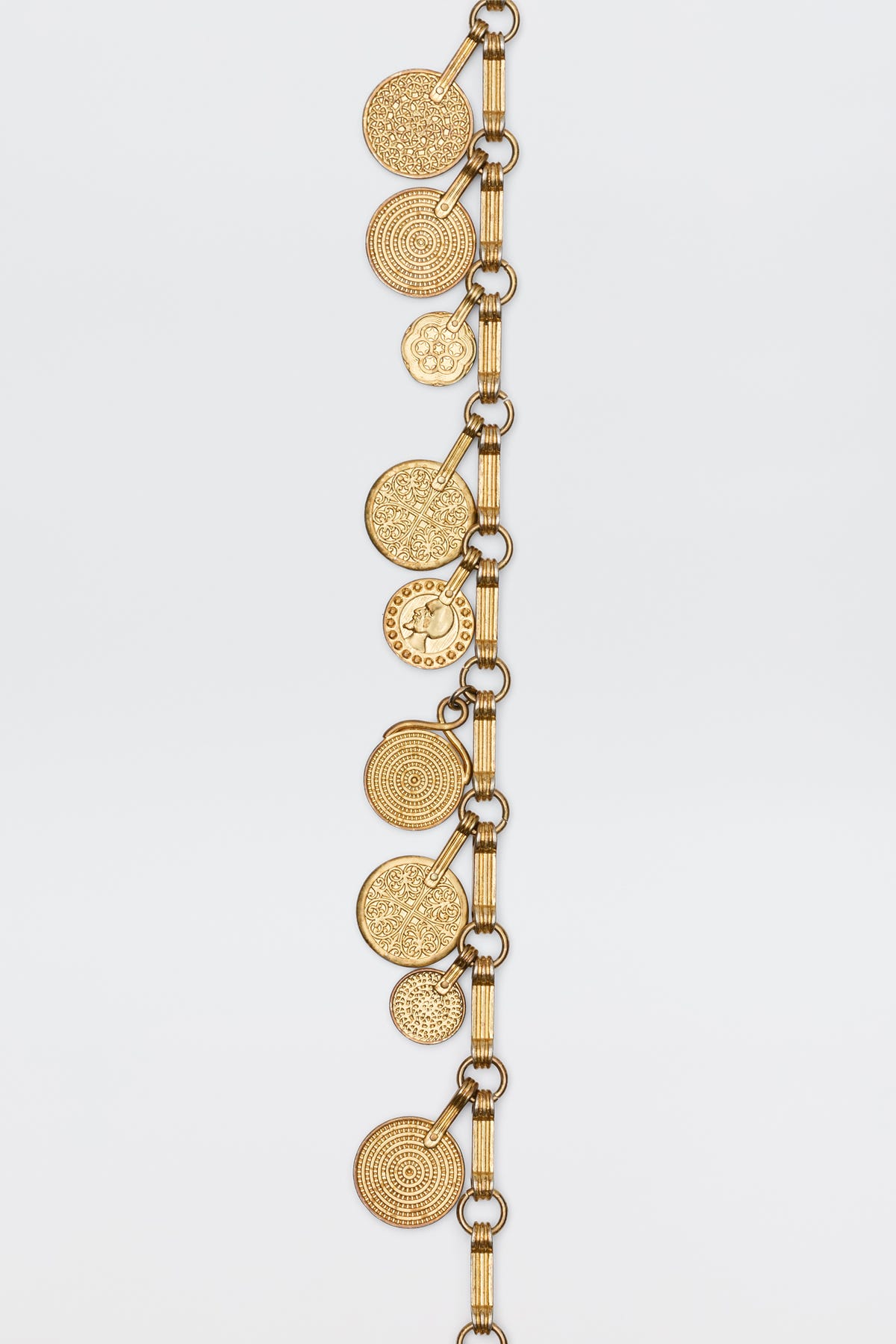The Isolde - Gold bracelet features a gold-toned chain with multiple round, textured disc charms for a vintage-inspired look, shown against a plain white background.