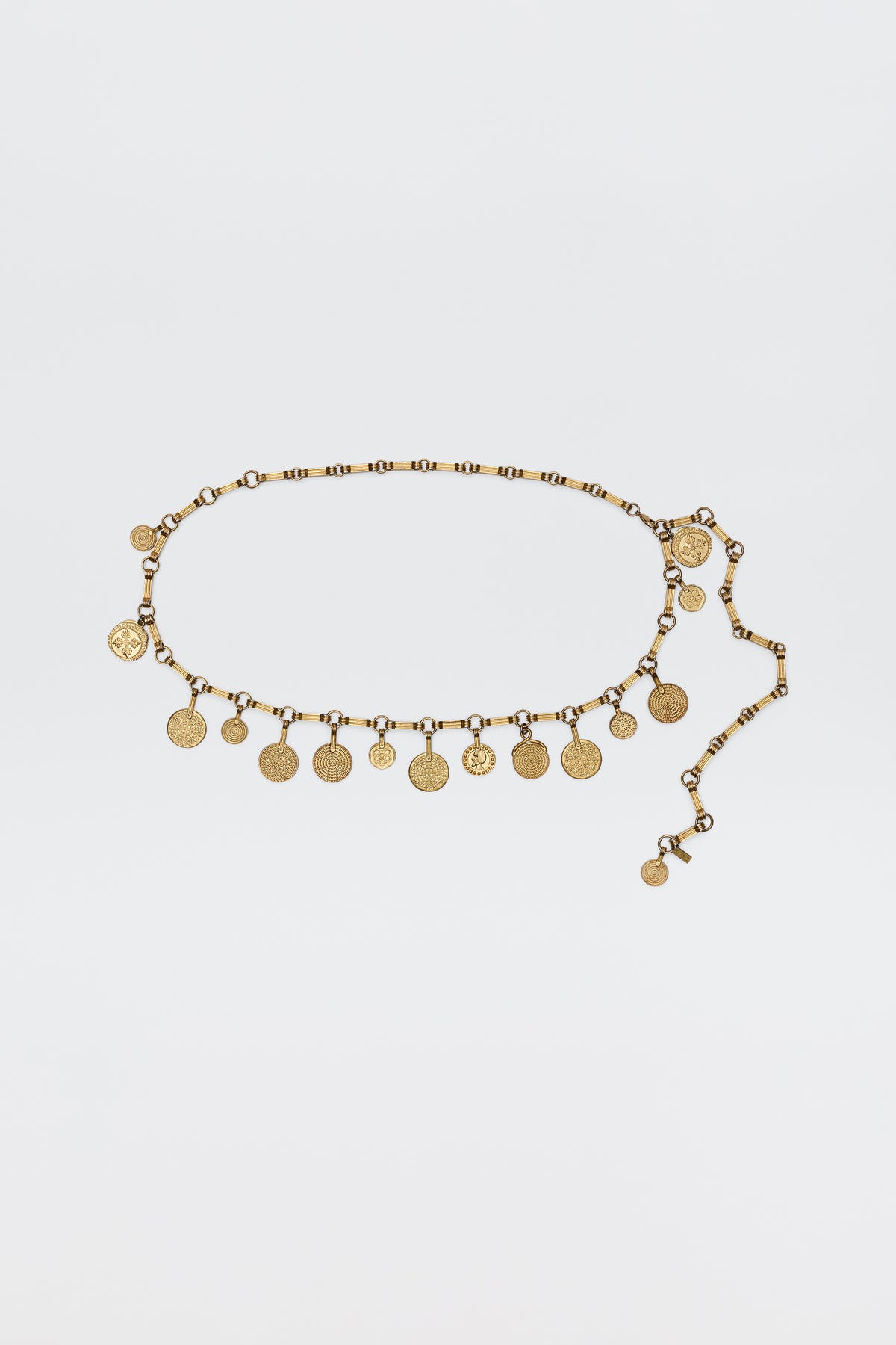 The Isolde - Gold belt features evenly spaced coin-shaped charms on a linked chain, bringing vintage glamour—ideal for pairing with RIXO dresses. Shown on a simple white background.