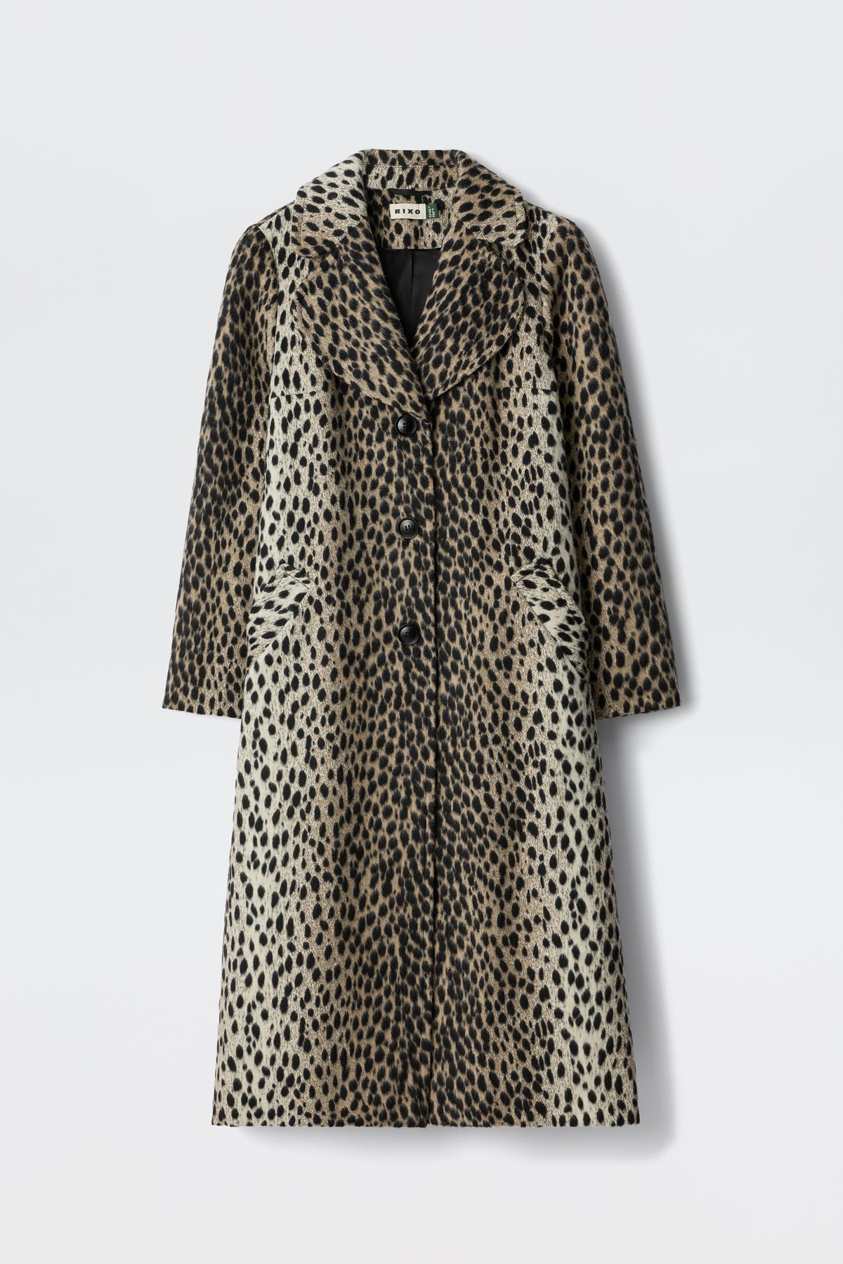 The Rosemary - Antelope Spot Jacquard Black is a long, knee-length coat with a spotted pattern, curved lapels, and three front buttons, shown against a plain white background.