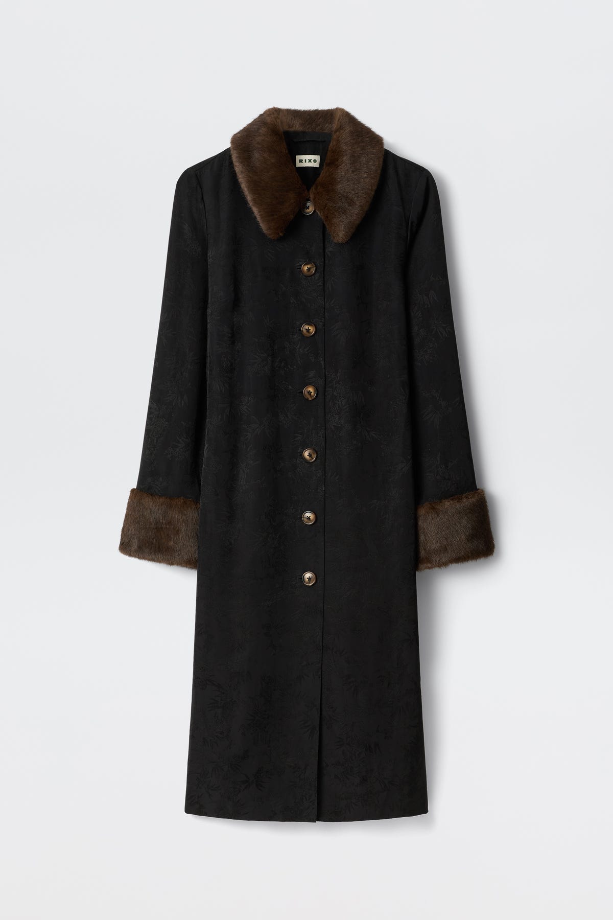 The Jonah - Black coat features a long black design with brown faux fur collar and cuffs, subtle textured pattern, and brown front buttons, shown against a plain white background.