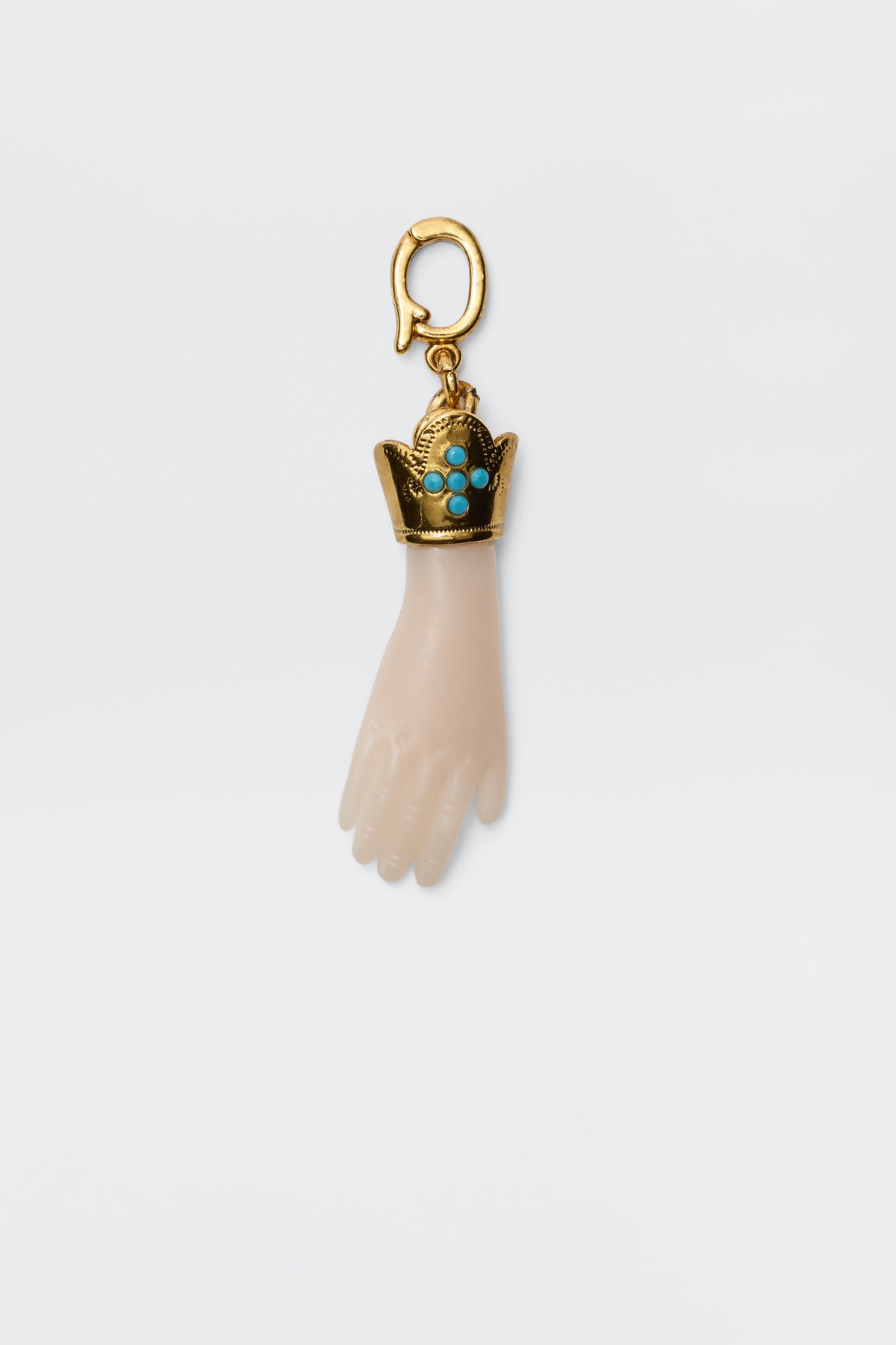 The Adara - Gold is a vintage-inspired gold-plated hand charm with a decorative crown set with turquoise stones, attached to a gold hook for a unique and elegant accessory.