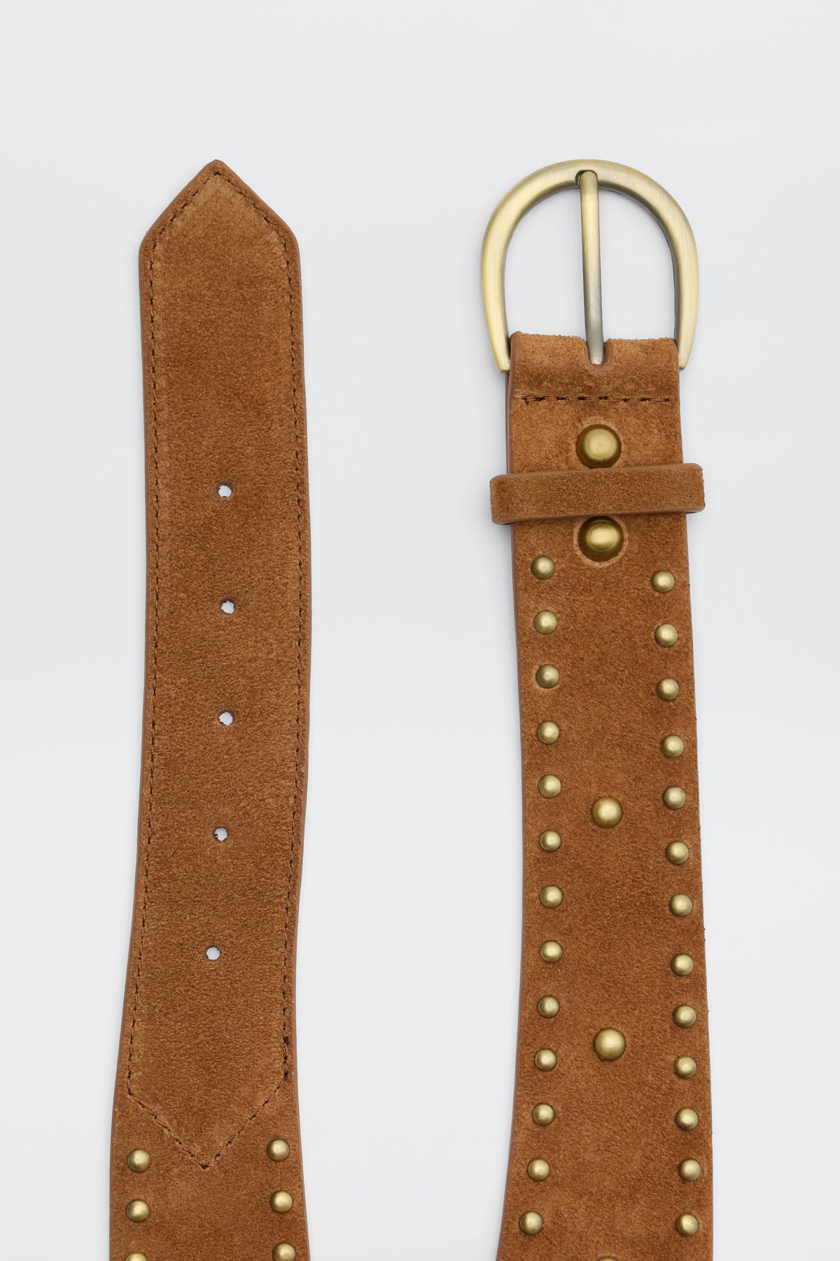 The Lorelei - Camel is a brown suede belt featuring gold metal studs and a rounded gold buckle, displayed both coiled and unfastened on a white background.