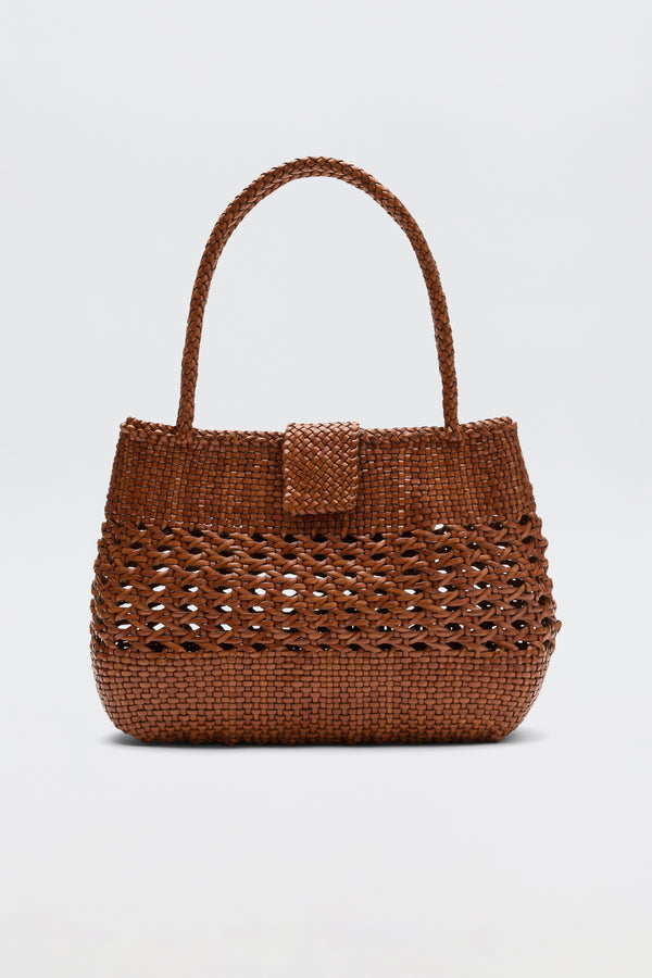 The Niamh - Tan by Dragon Diffusion features a single top handle, flap closure, and textured design in brown, elegantly displayed on a white background—a stylish take on vintage woven bags.