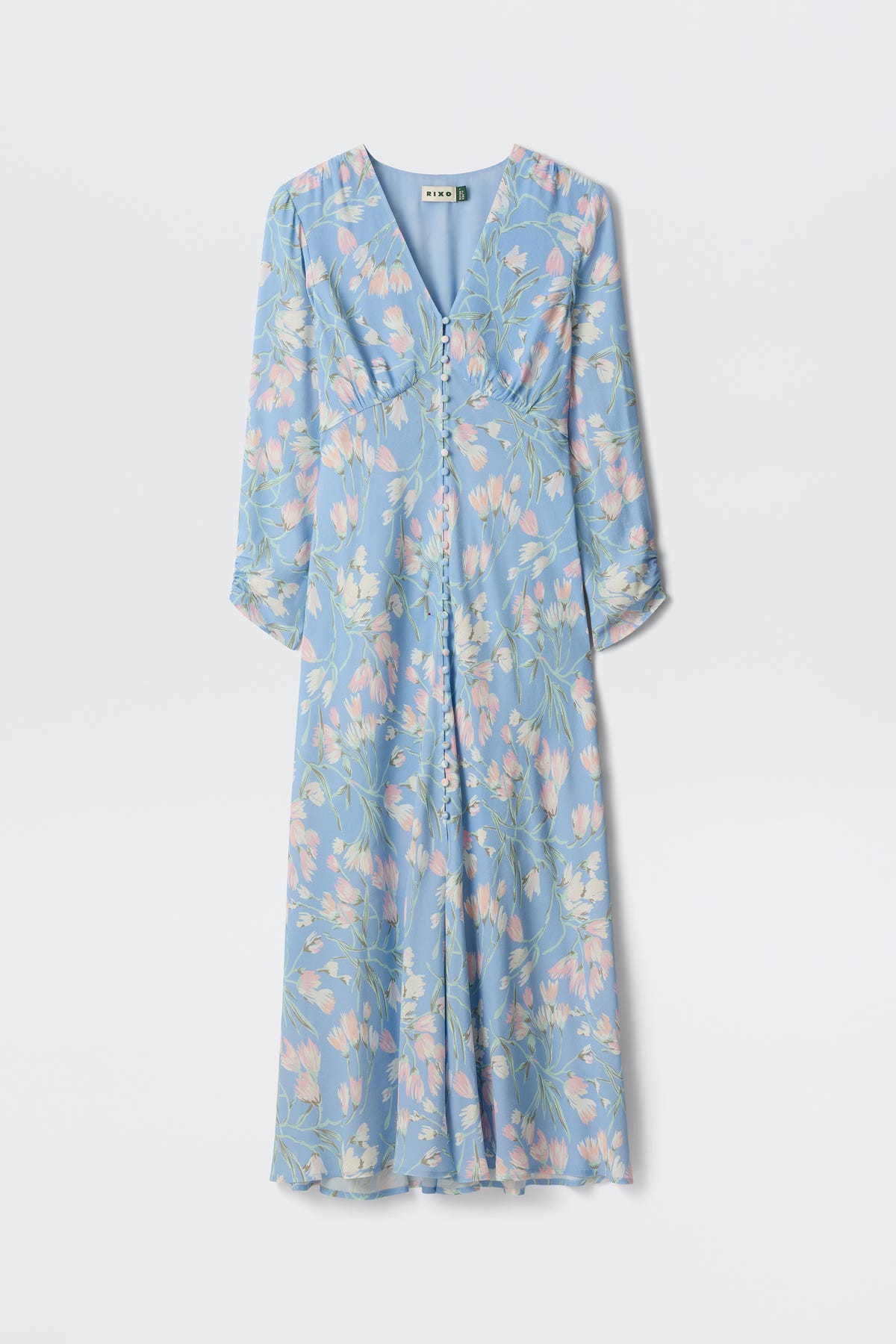 The "Katie - Watercolour Floral Blue" is a long-sleeved, ankle-length blue dress with a V-neckline and pastel pink and green floral patterns, shown against a plain white background.