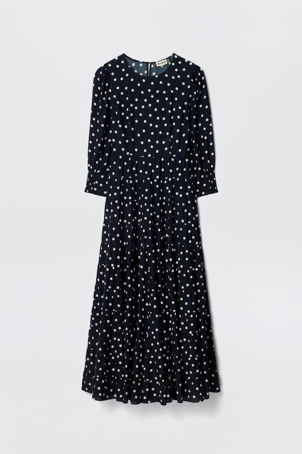 The Kristen - Bohemia Spot Navy is a vintage-inspired, long-sleeved, ankle-length dress in navy with classic spot print, fitted waist, and flared skirt, shown against a plain white background.