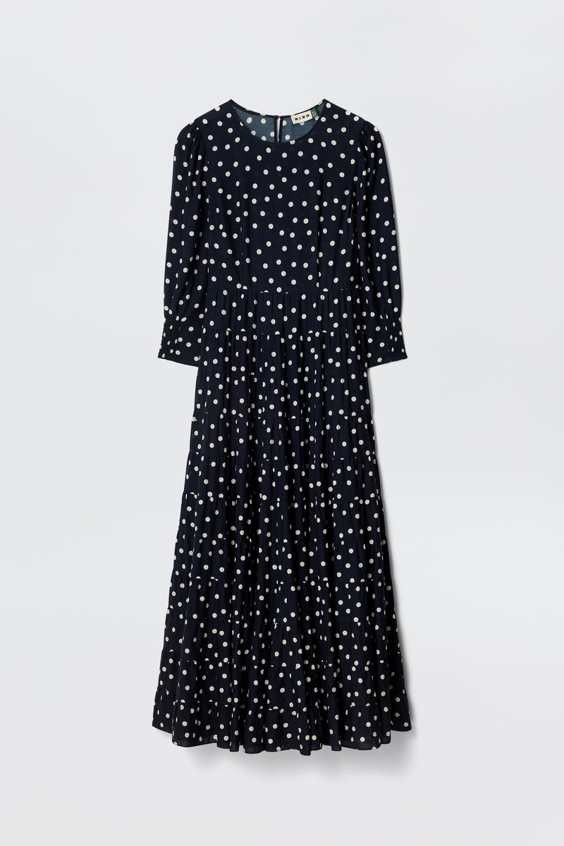 The Kristen - Bohemia Spot Navy is a vintage-inspired, long-sleeved, ankle-length dress in navy with classic spot print, fitted waist, and flared skirt, shown against a plain white background.