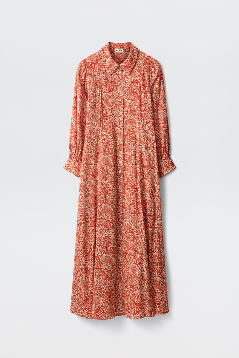 The Maddison - Woodcut Gremlin Red is a long-sleeved, ankle-length dress featuring a red and white paisley pattern, collared neckline, and front button details, shown against a plain light background.