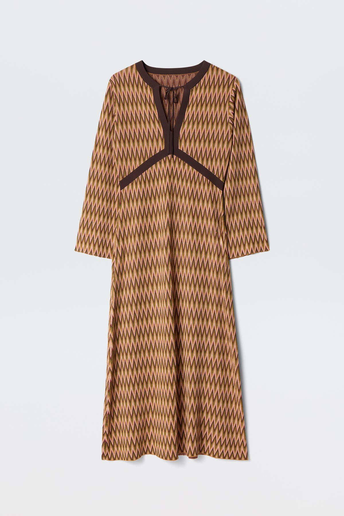 The Pamela - Maeve Jacquard Multi is a long-sleeved, knee-length dress featuring a brown, yellow, and beige zigzag pattern with dark brown trim along the neckline and chest, shown on a plain white background.