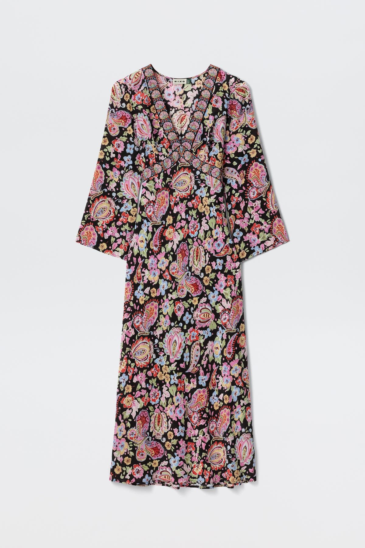 The Tania - Cara Floral Black is a long-sleeved V-neck maxi dress with a vibrant floral and paisley pattern on a black background, shown flat on a white surface.