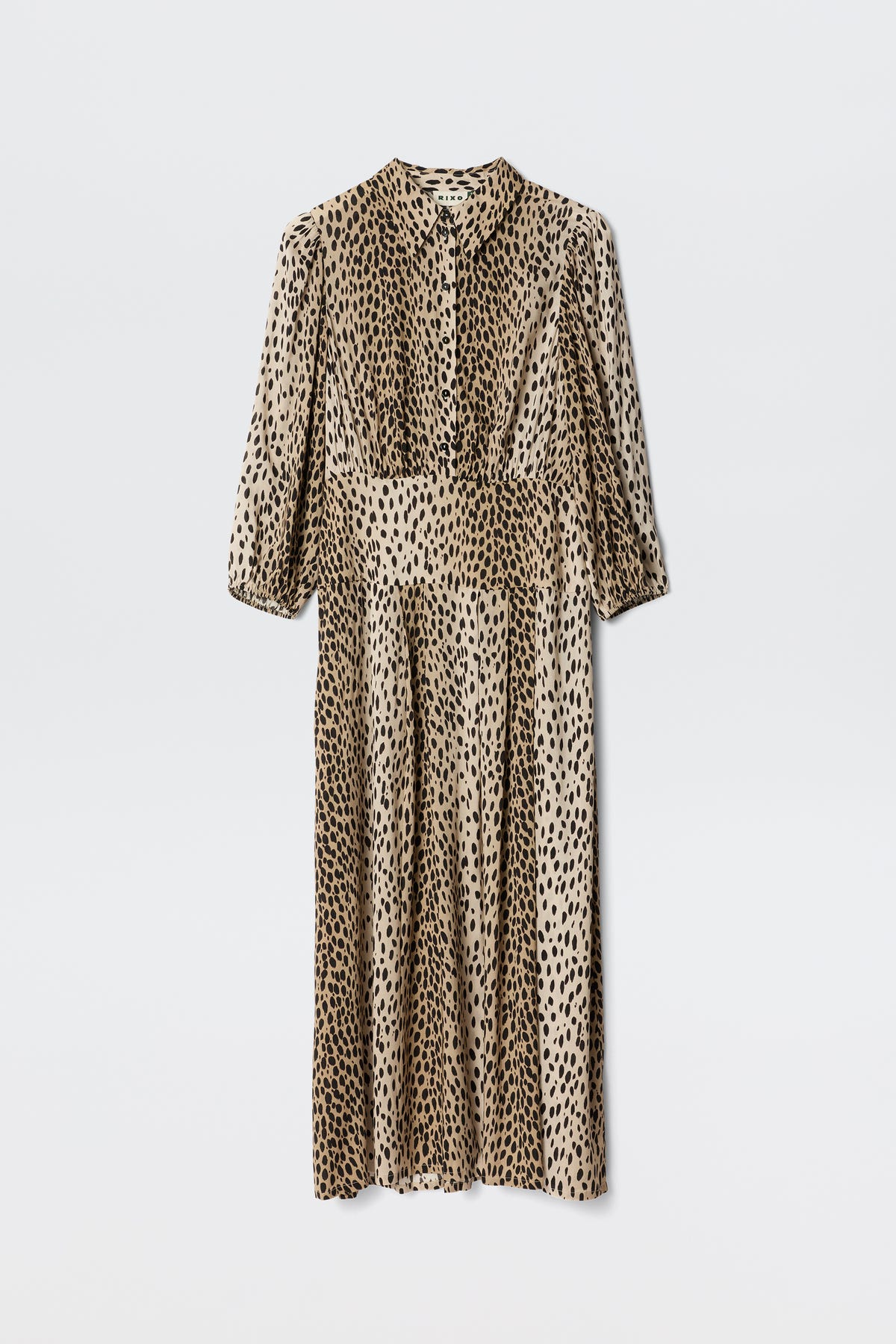 The Izzy - Antelope Spot Black is a long-sleeved, button-up shirt dress with a beige base and black leopard print, pleated skirt, ideal for work or weekends. Displayed on a plain white backdrop.