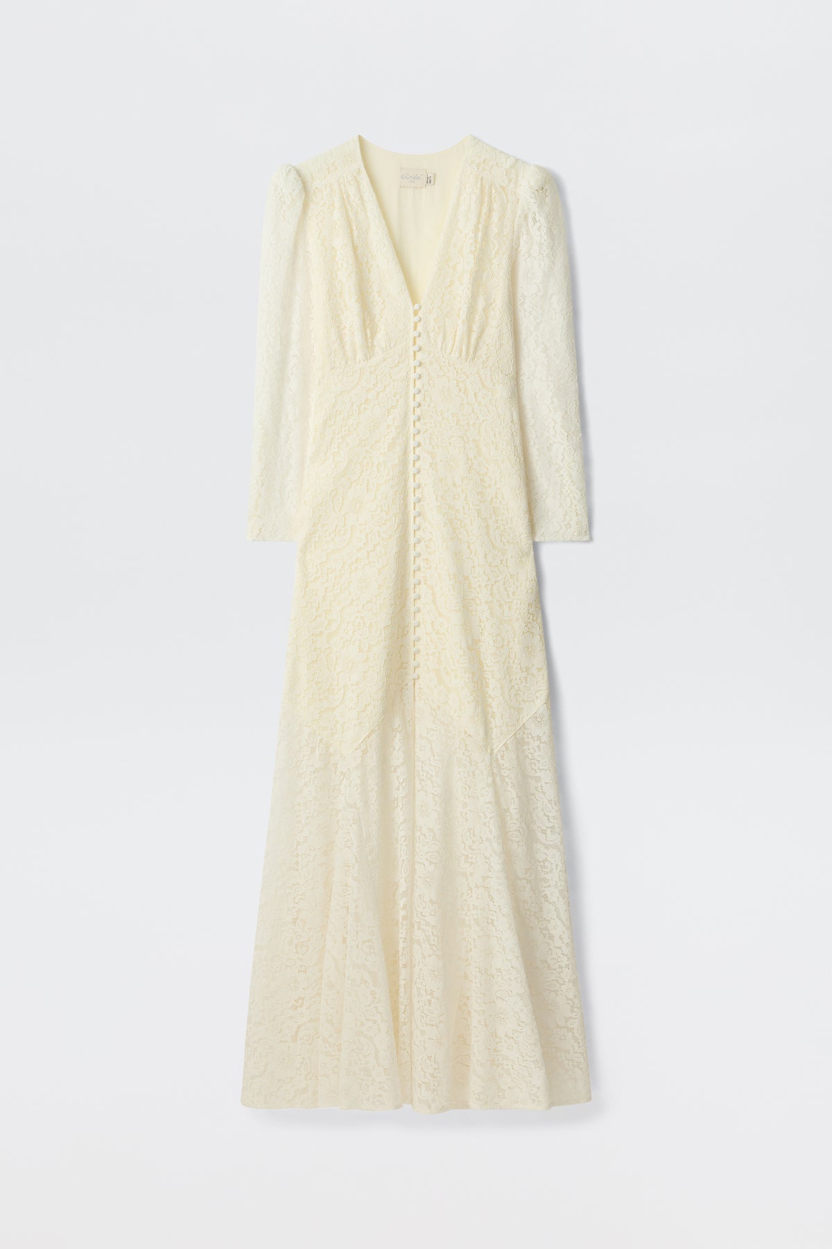The Fleur - Ivory is a long-sleeved, floor-length ivory corded lace dress with a V-neckline, covered front buttons, and a subtle fit-and-flare silhouette, shown on a plain white background.