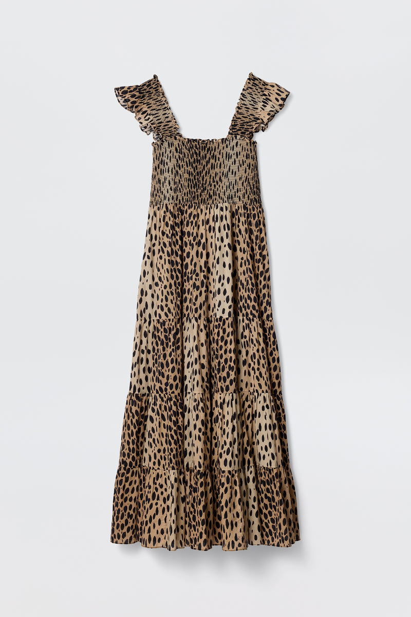 The Kendall - Antelope Spot Black is a sleeveless, ankle-length cotton-voile dress with ruffled straps, smocked bodice, and tiered skirt in a bold leopard print, shown against a plain white background.