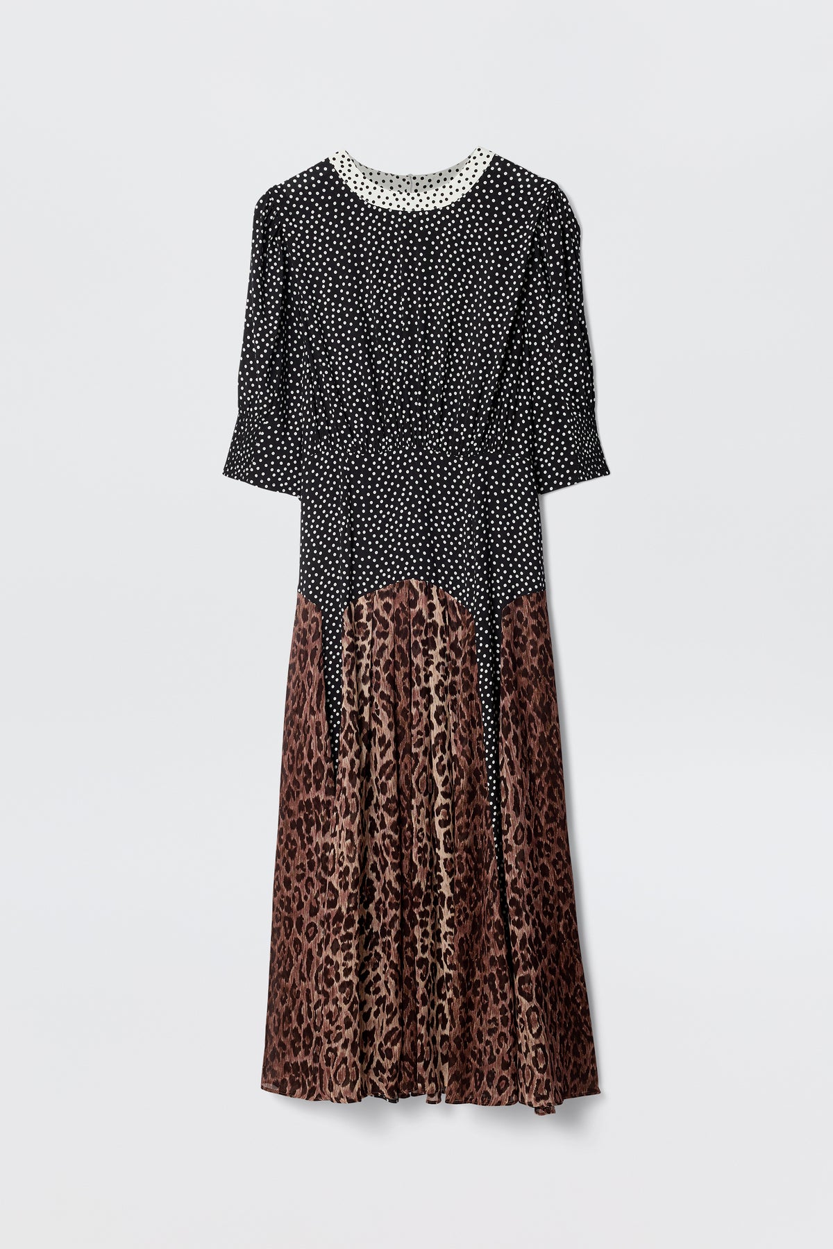 The "meg - leopard polka dot" dress features a black and white polka dot top with sleeves, a white lace-trimmed collar, and a brown leopard print midi skirt, displayed against a plain white background.