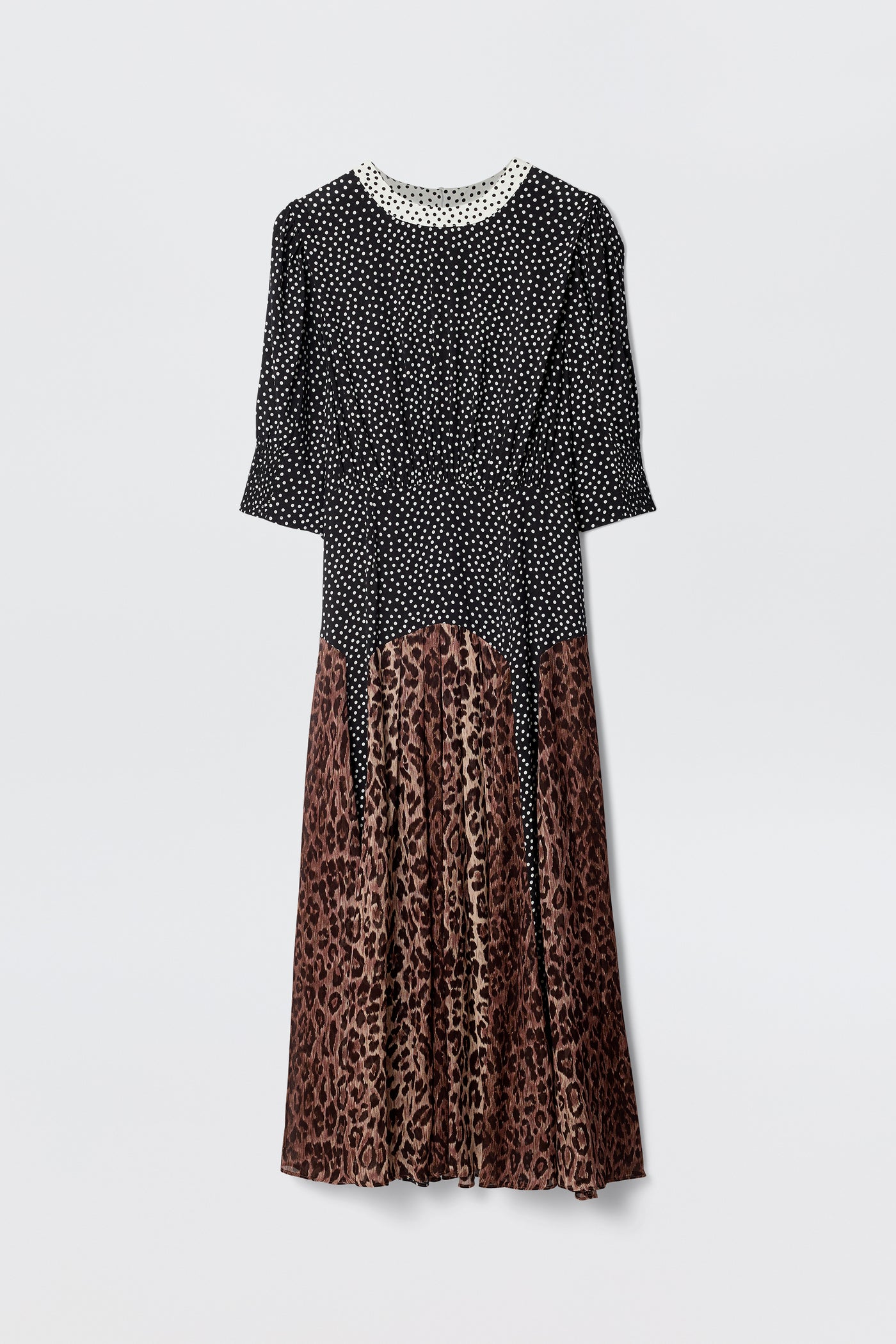 The "meg - leopard polka dot" dress features a black and white polka dot top with sleeves, a white lace-trimmed collar, and a brown leopard print midi skirt, displayed against a plain white background.