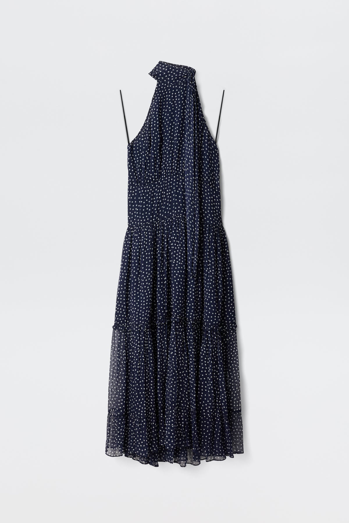 The Abi - Mini Navy Polka Dot is a sleeveless navy georgette mini dress with white polka dots, thin straps, a halter neckline, and an attached scarf detail, shown against a plain white background.