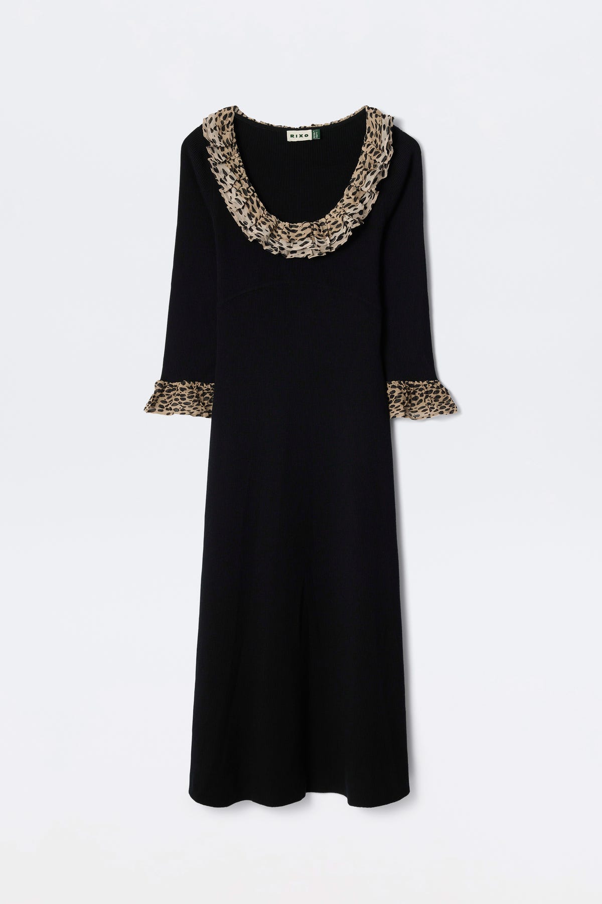 The Mika - Antelope Spot Black is a long-sleeved black scoop neck dress with wide ruffled neckline and sleeve cuffs, featuring a brown and black antelope spot print, displayed on a plain white background.