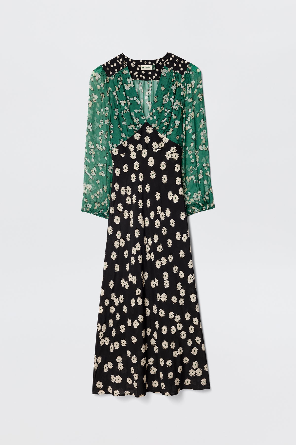 The Kaila - City Floral Mix Olive is a vintage-inspired midi dress with sheer green sleeves, a white floral print bodice, and a black skirt featuring matching white floral patterns.