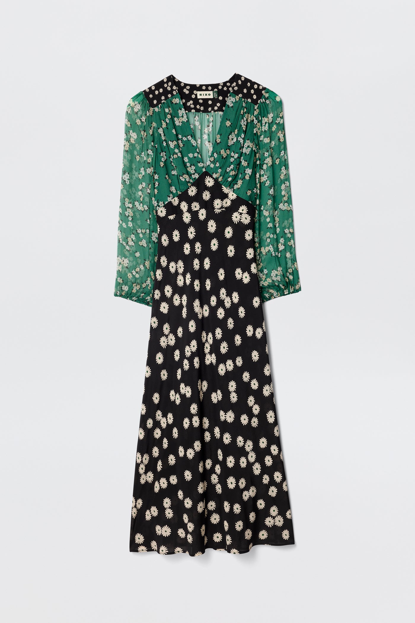 The Kaila - City Floral Mix Olive is a vintage-inspired midi dress with sheer green sleeves, a white floral print bodice, and a black skirt featuring matching white floral patterns.