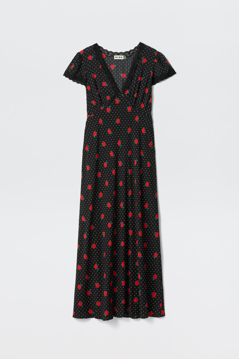 The Clarice - Rose Spot Black is a black V-neck, short-sleeve maxi dress featuring red polka dots and smaller white dots, shown on a plain white background.