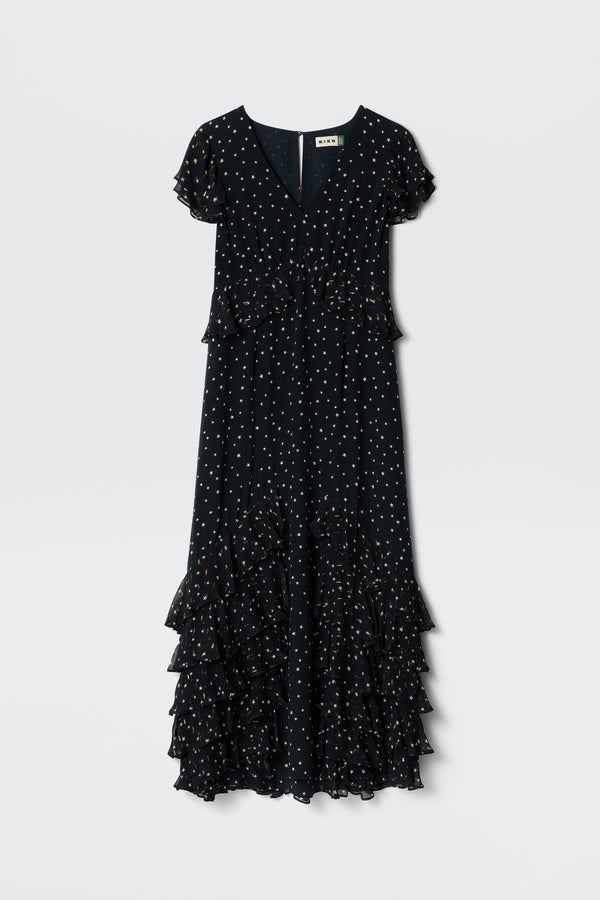 A short-sleeved, V-neck Thanvi - Starry Night Navy dress with white polka dots and cascading georgette ruffles along the skirt, shown on a plain light background.