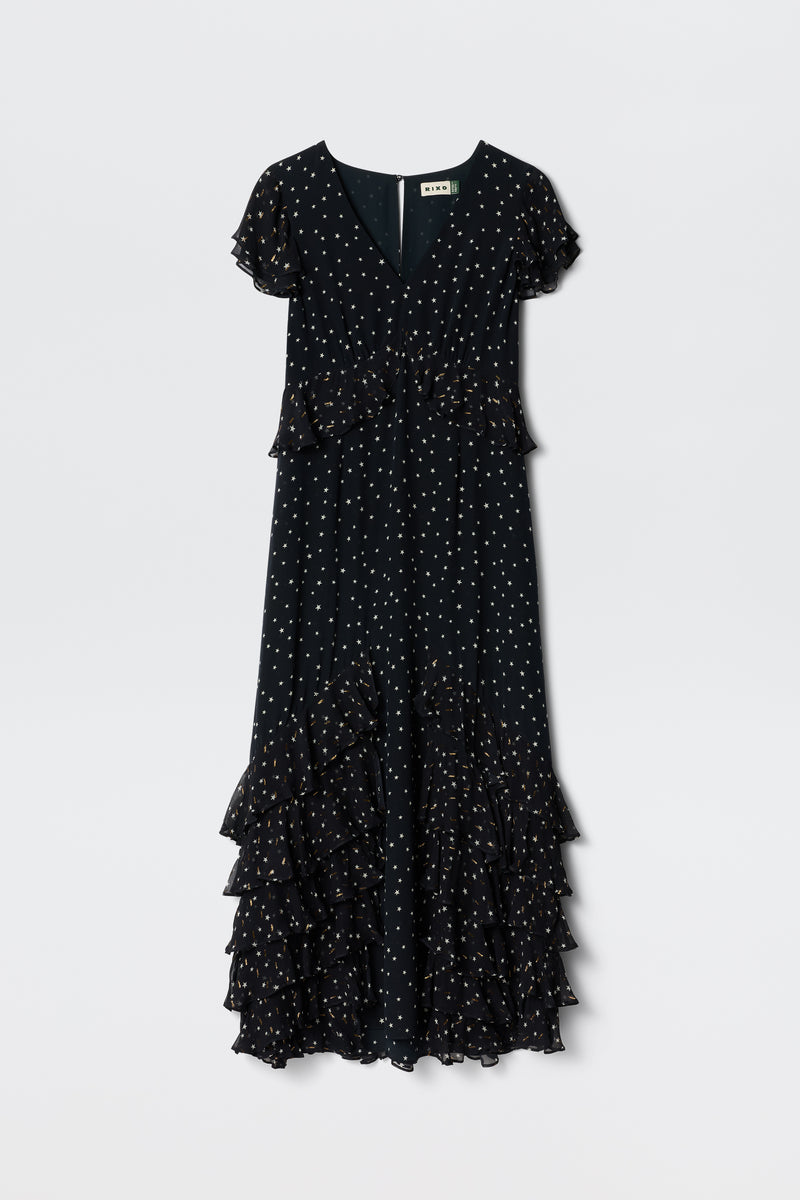 A short-sleeved, V-neck Thanvi - Starry Night Navy dress with white polka dots and cascading georgette ruffles along the skirt, shown on a plain light background.