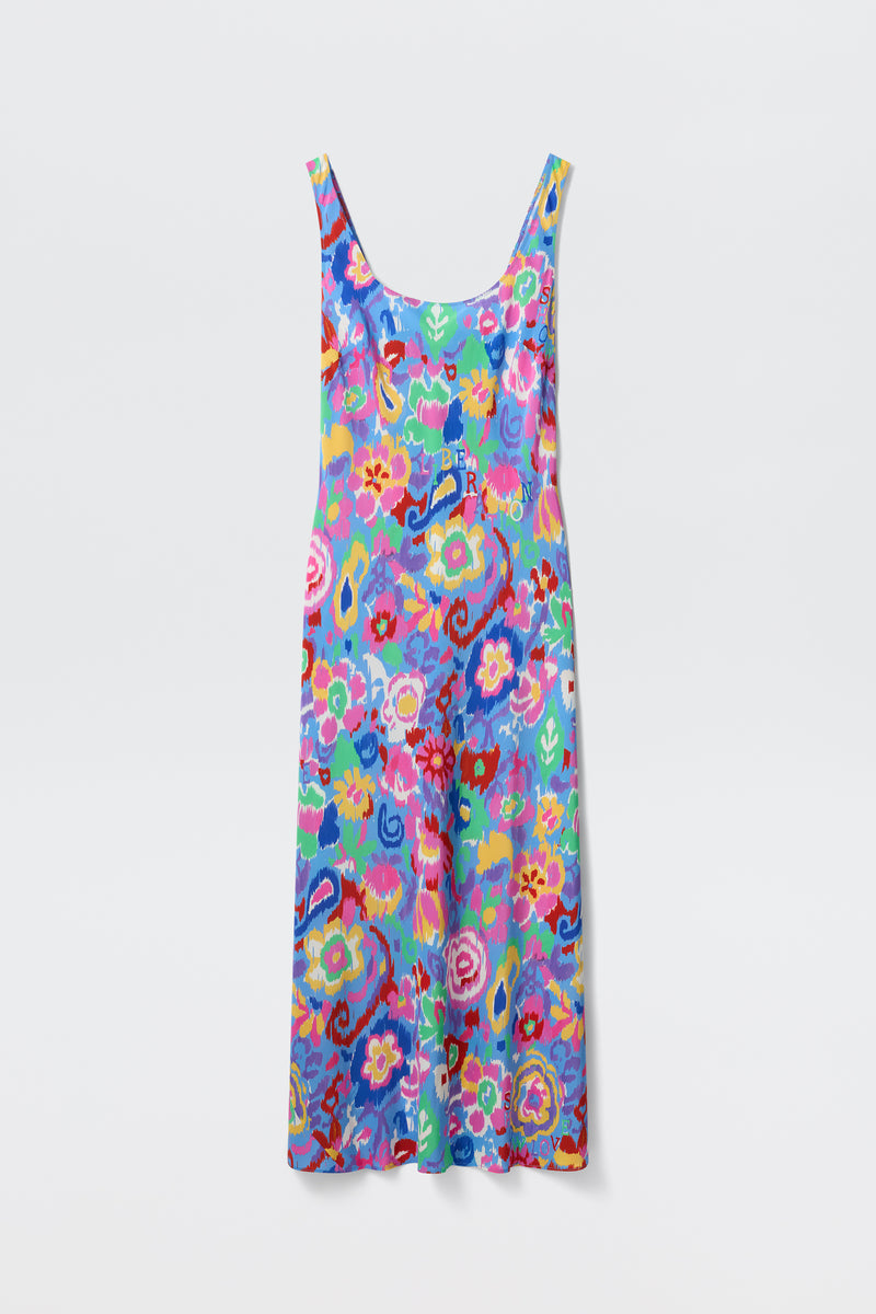 The Bondi - Ikat Bloom Lilac is a sleeveless, ankle-length dress featuring a colorful floral pattern in blue, pink, yellow, green, and red hues, displayed on a plain white background.
