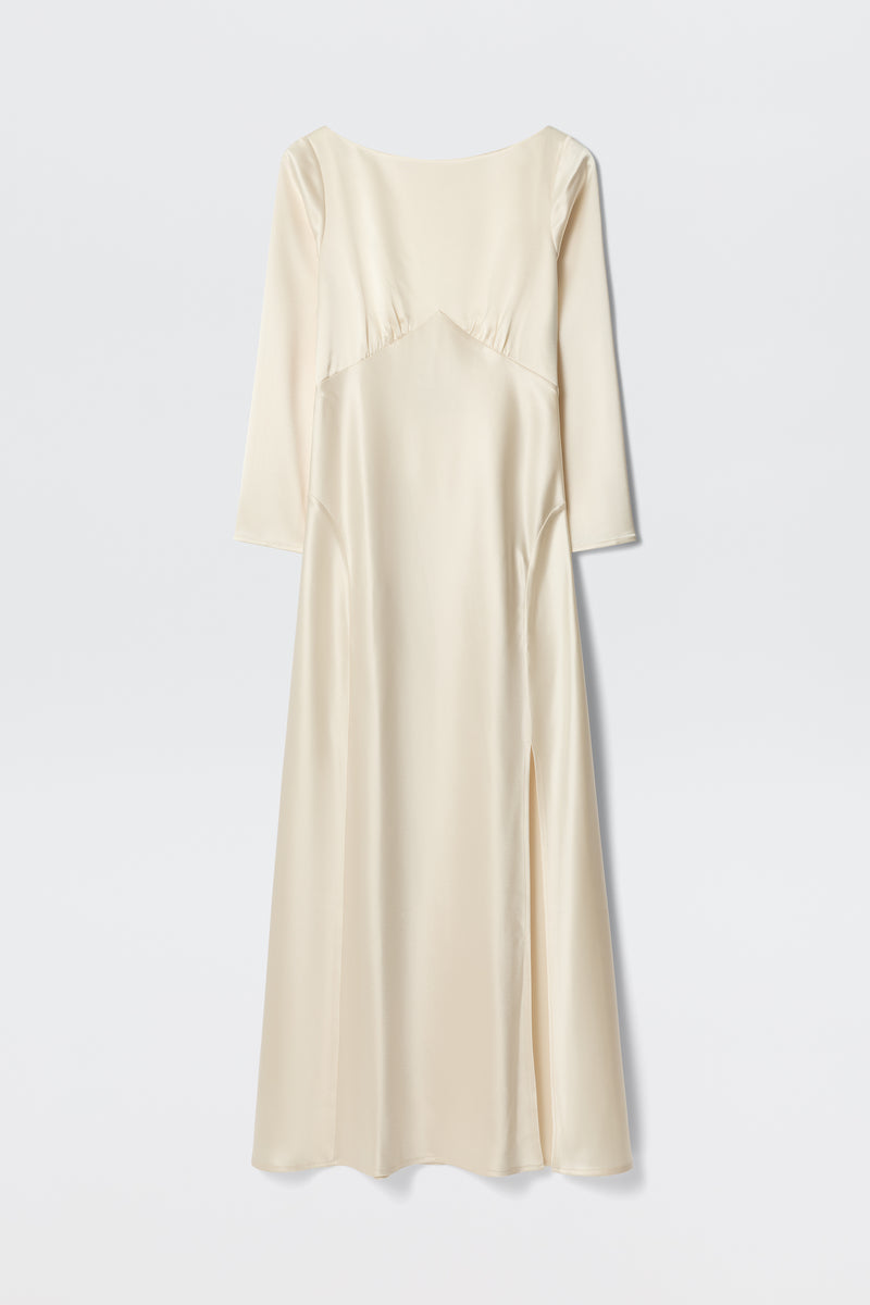 The Devina - Pearl is a long ivory satin dress with three-quarter sleeves, a fitted bodice featuring subtle seam details, and a slight side slit. Its minimalist, elegant design is shown against a plain white background.