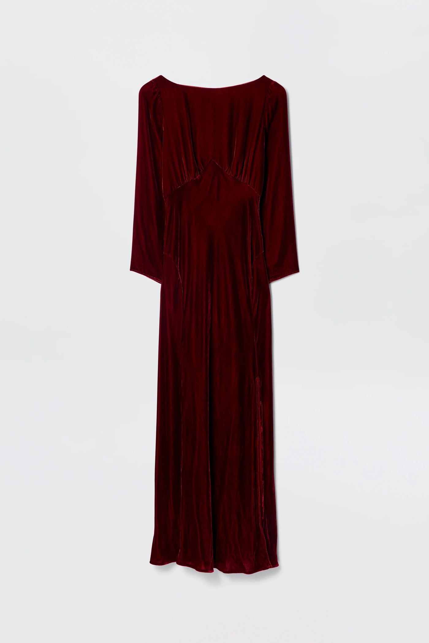 The Devina - Burgundy is a long-sleeved, floor-length velvet gown in deep red, featuring a fitted waist and slightly flared skirt for old-Hollywood elegance, showcased against a plain white background.