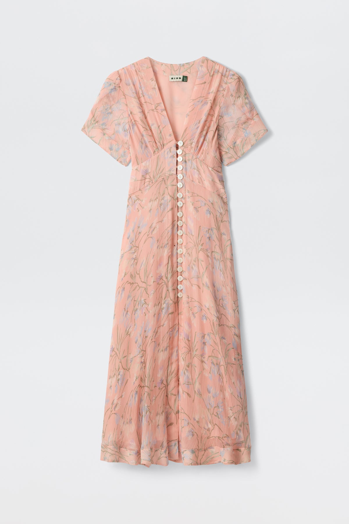 The Novara - Watercolour Floral Pink is a light pink, short-sleeved maxi dress with a V-neckline, white front buttons, soft flowing fabric, and a subtle botanical floral print.