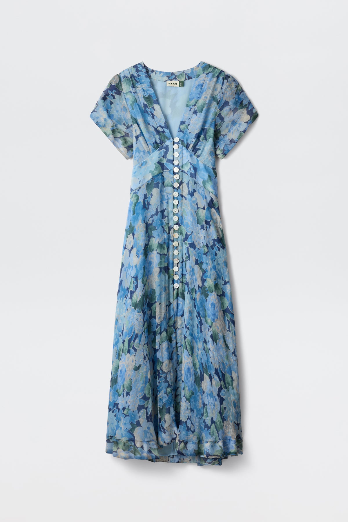 The Novara - Chelsea Floral Blue is an ankle-length, short-sleeve dress with a blue floral pattern, V-neckline, white front buttons, and flowy lightweight fabric for a soft, elegant look.