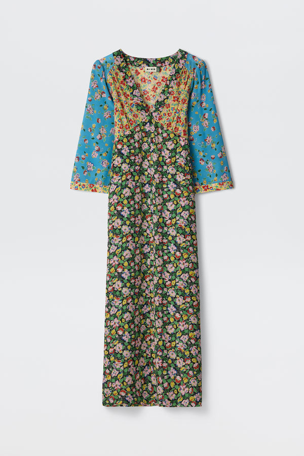 The Dahlia Jeannie Mix Multi is a long-sleeve, V-neck maxi dress featuring blue sleeves and upper section with small florals, and a black main body adorned with a dense, colorful floral print.