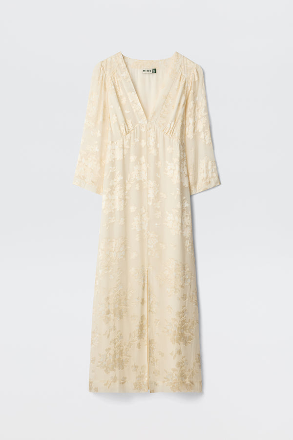 The Dahlia - Bouquet Devore Cream is a long, cream-colored dress with a V-neckline, three-quarter sleeves, and a delicate floral pattern, shown against a plain white background.