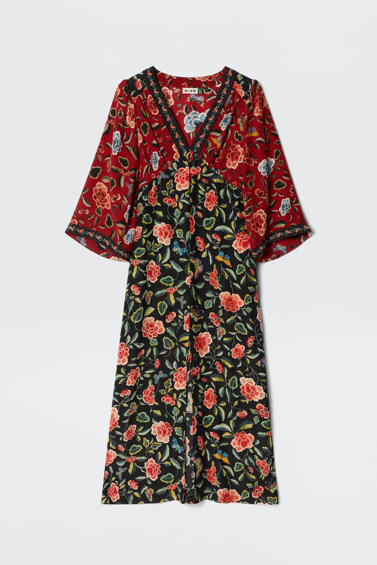 The Dahlia - Butterfly Mix Black is a long-sleeved maxi dress with a V-neck, adorned with chinoiserie florals in red, green, and cream on black and red fabric, plus contrasting sleeve and bodice patterns for standout style.