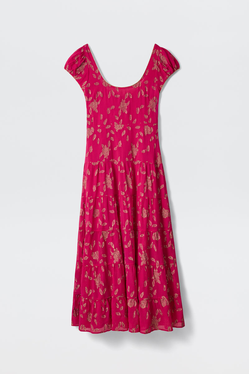 The Remi - Floral Spark Jacquard Magenta Pink dress is a bright pink, short-sleeved, knee-length piece with a scoop neckline, flared skirt, and subtle floral print, shown against a white background.