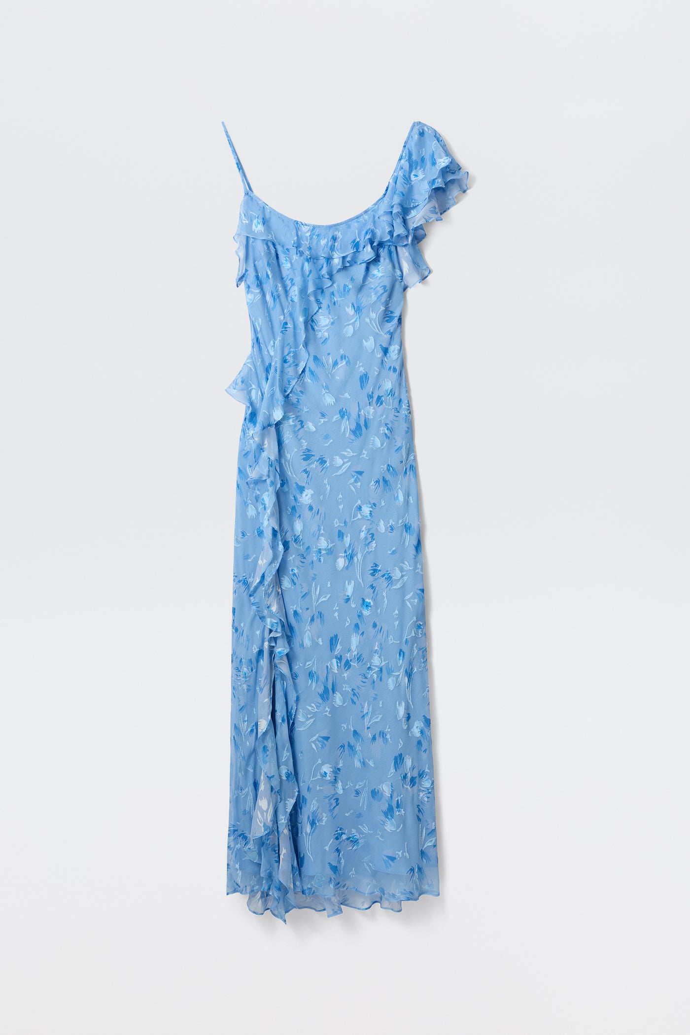 The Ester - Ava Devore Blue is a light blue, sleeveless asymmetrical maxi dress with ruffled trim and a floral pattern, shown against a plain white background.