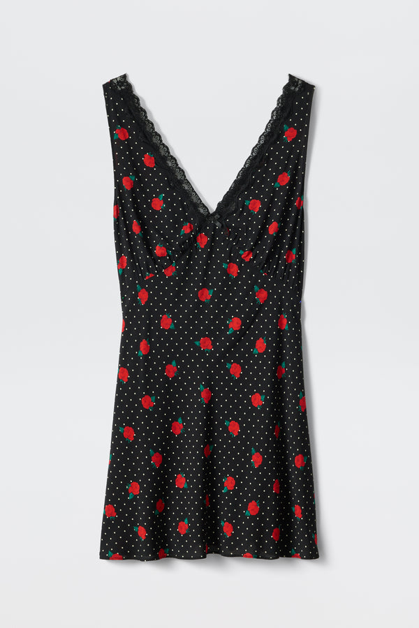 The Leighton - Rose Spot Black is a sleeveless black dress with a V-neckline trimmed in lace, adorned with small white polka dots and scattered red rose patterns.