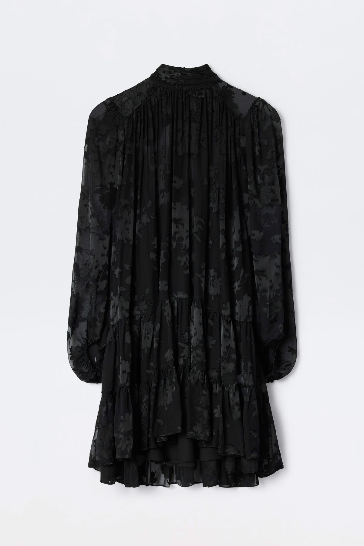 Anaya - Bouquet Devoré Black: Elegant, long-sleeve black dress featuring a floral devoré pattern, ruffled hem, and gathered back details, shown against a plain white background.