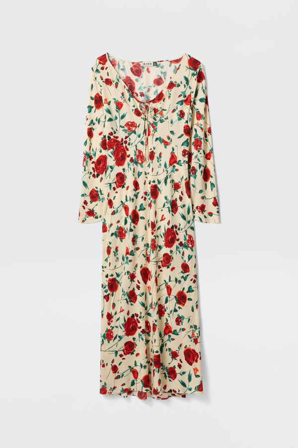 The Gwenyth - Claudia Rose Cream is a cream-colored, ankle-length dress featuring long sleeves, a red rose floral print, and a tie neckline, shown on a plain white background.