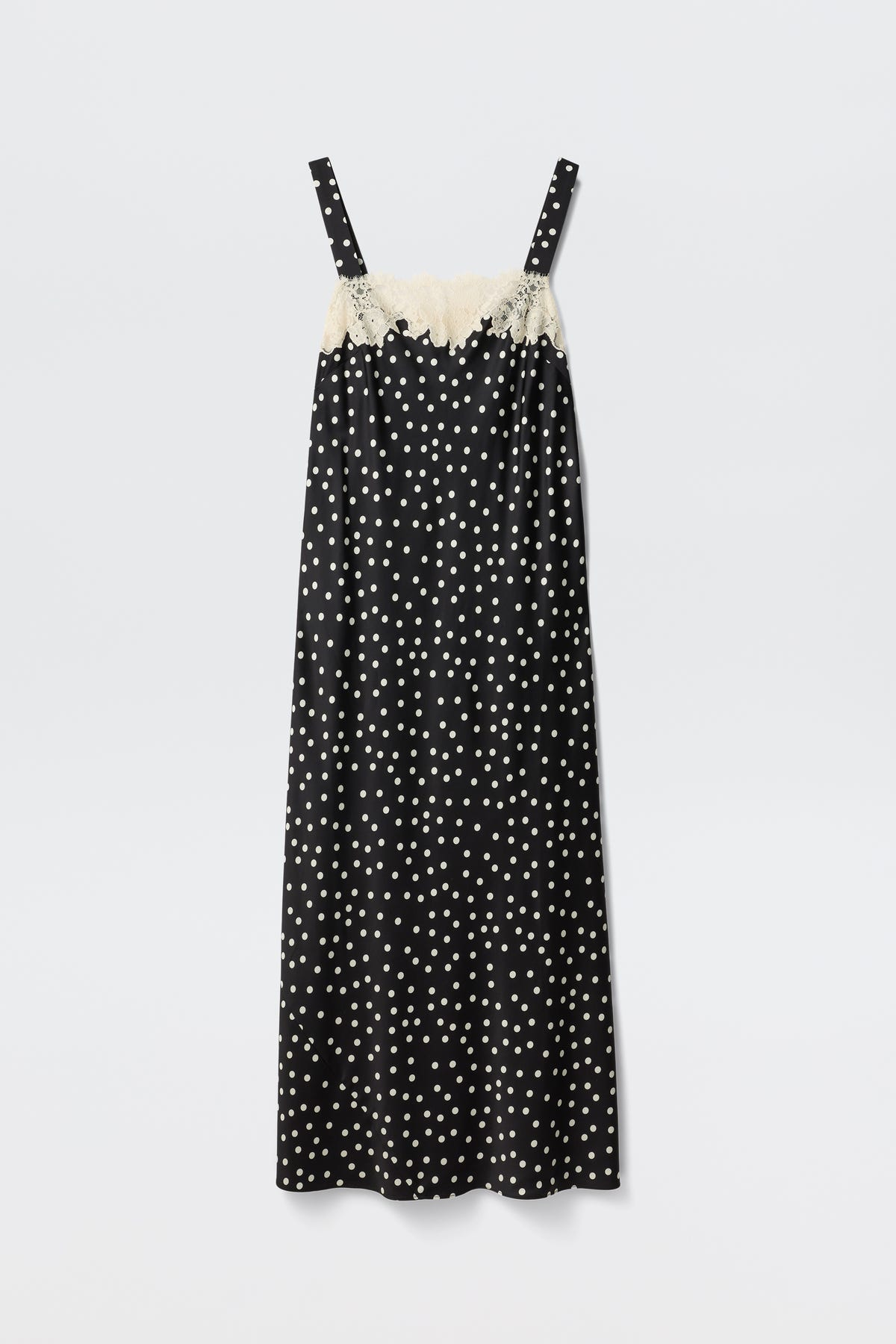 The Rosamarie - Scattered Dot Black is a black sleeveless slip dress featuring white polka dots and cream lace trim along the top edge, shown against a plain white background.