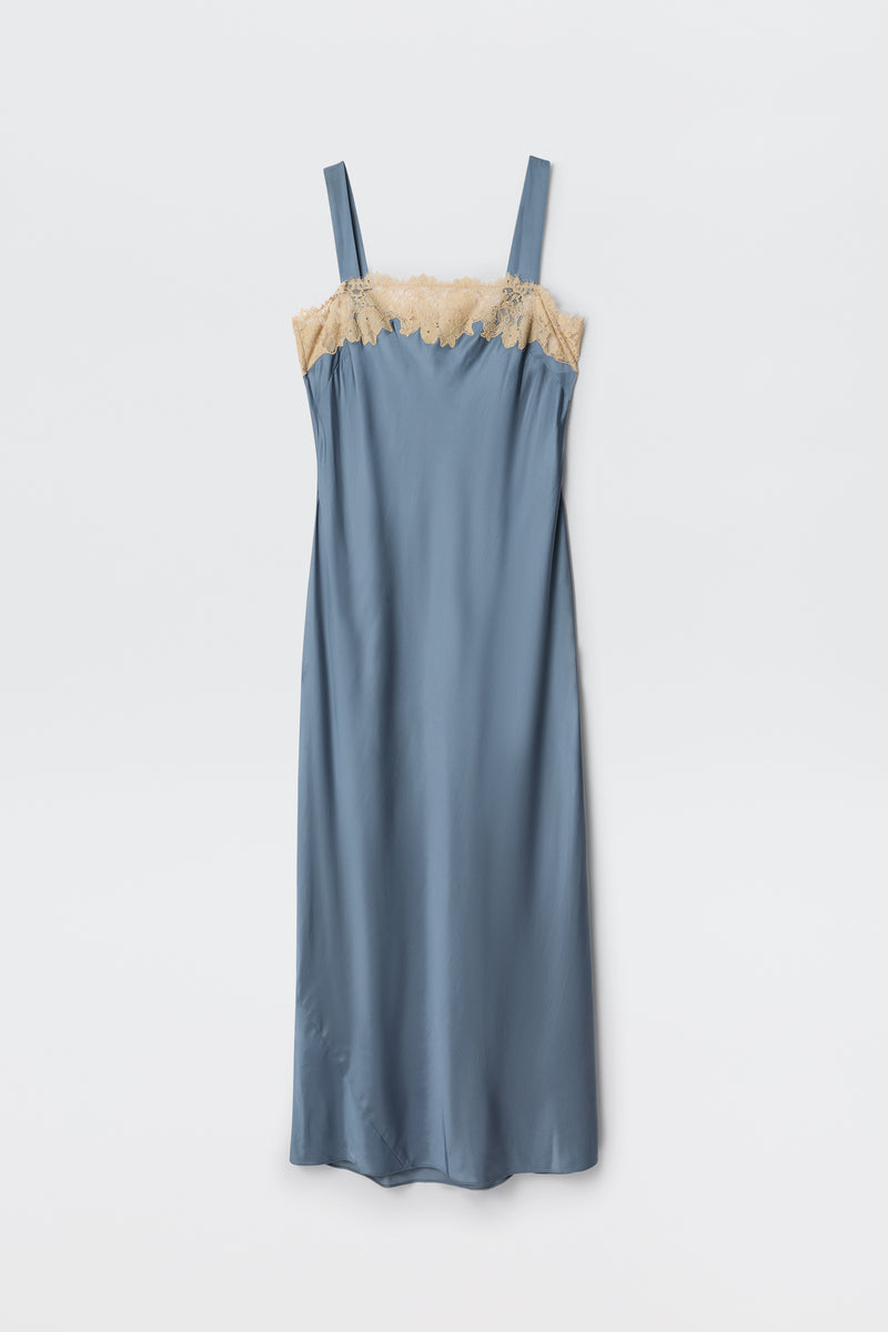 The Rosamarie - Stone Blue is a satin slip dress with wide shoulder straps and a straight cut, featuring beige lace trim along the top edge. The dress is shown flat on a white background.