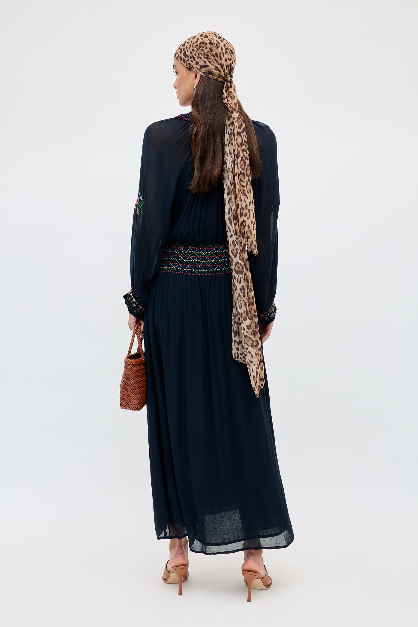 A woman wearing the Emilio - Petunia Embroidery Navy long dress.